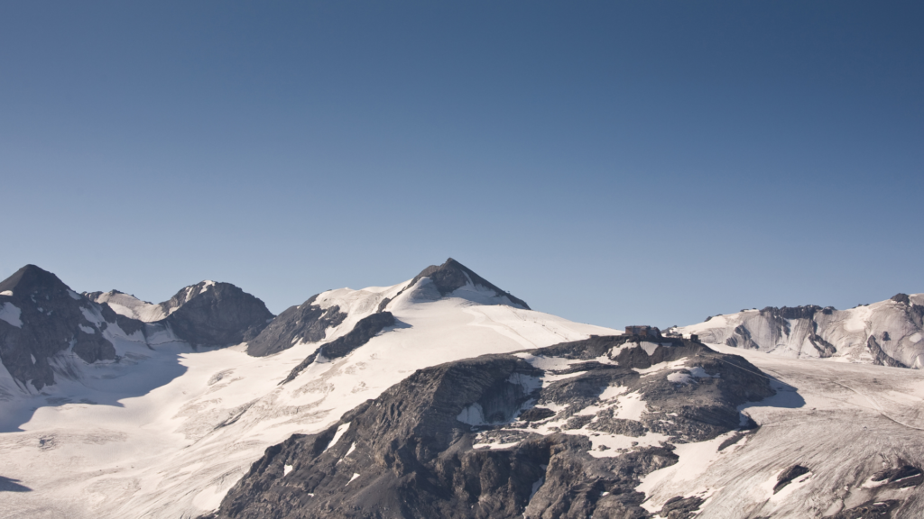 Zasneženi alpski vrhovi in ledeniki smučišča Pejo v Narodnem parku Stilfserjoch - idealna destinacija za zimske počitnice.